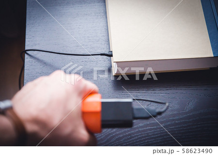 E-book and book connected with cable. White 58623490