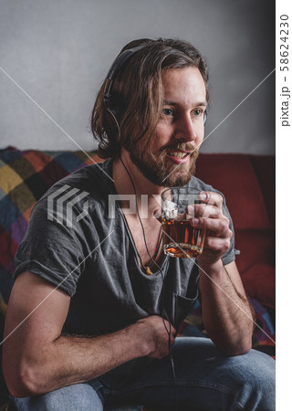 Bearded man listening to music with headphones Bearded man listening to music with headphones 58624230