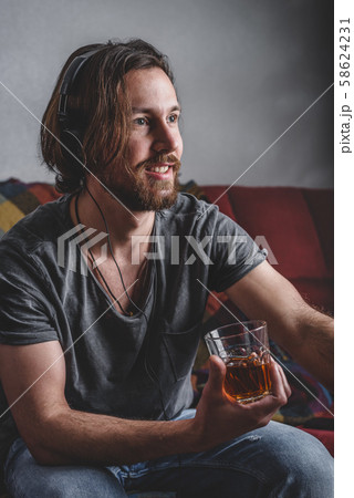Bearded man listening to music with headphones 58624231