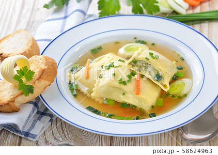 Vegetable broth with Swabian-style stuffed ravioli (so called 'Maultaschen') served with toast 58624963
