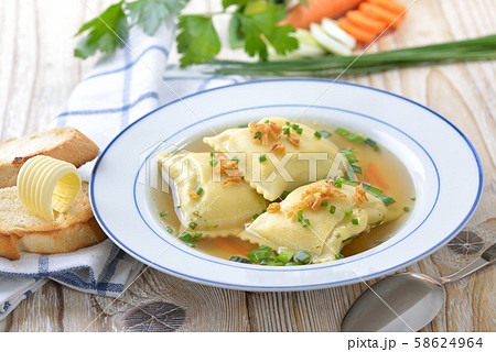 Vegetable broth with Swabian-style stuffed ravioli (so called 'Maultaschen') served with toast 58624964