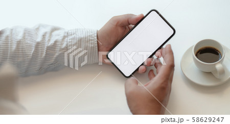 Businessman holding blank screen smartphone in 58629247