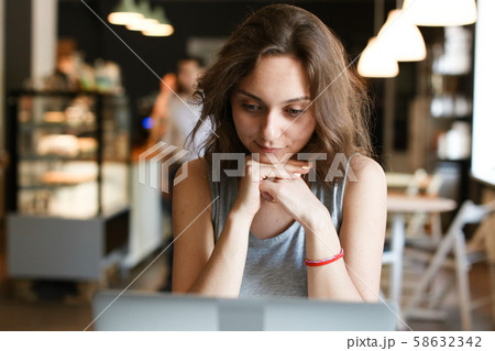 Female student working with laptop at cafe. Female student working with laptop at cafe. 58632342