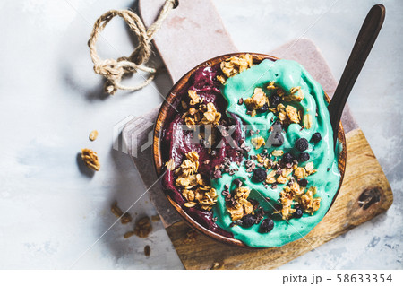 Healthy vegan breakfast. Blue spirulina and berry smoothie bowl 58633354