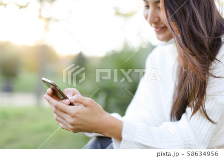 Focus on smartphone in chinese girl hands. 58634956
