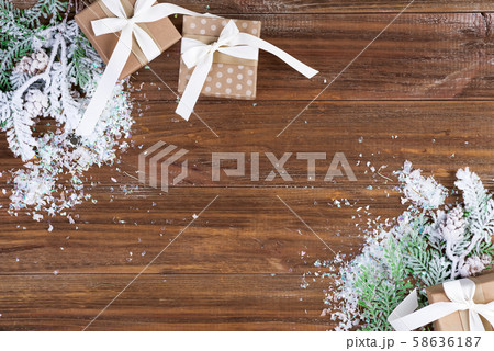 Gift boxes with fir branches and snow on a wooden background. Christmas card. Flat lay copy space Gift boxes with fir branches and snow on a wooden background. Christmas card. Flat lay copy space 58636187