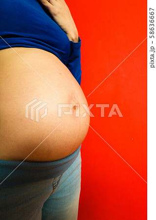 Adult woman showing her pregnant belly 58636667