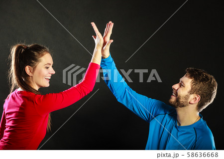 Friends man and woman celebrating giving high five 58636668