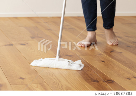 木目の床をモップがけする若い女性の足元 58637882