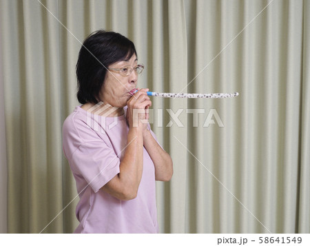 吹き戻しを吹くシニア女性 58641549
