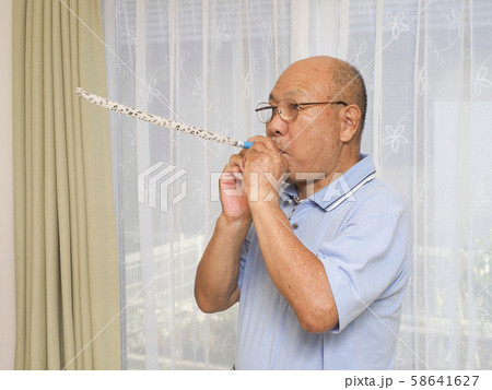 吹き戻しを吹くシニア男性 58641627