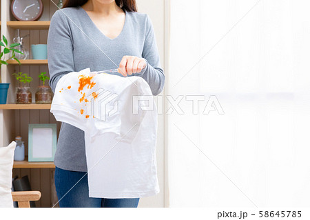 歯ブラシで服の汚れを落とす女性 歯ブラシで服の汚れを落とす女性 58645785