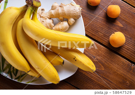 fresh fruits  bananas and apricots laying at  58647529