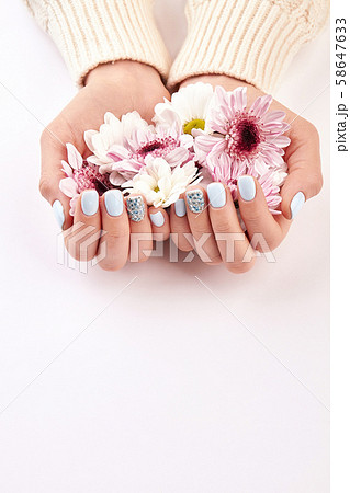 Beautiful blue manicure with delicate flowers. Beautiful blue manicure with delicate flowers. 58647633