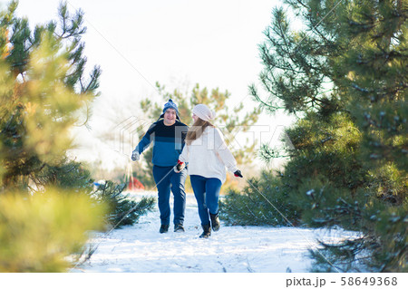 A loving couple holding hands runs through the A loving couple holding hands runs through the 58649368