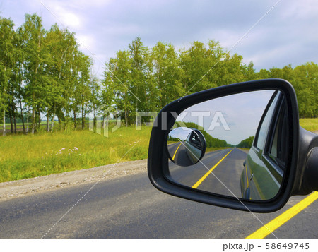 The insured car is a guarantee of safety. Traveling by car with the whole family. View through the car window to the rearview mirror. The insured car is a guarantee of safety. Traveling by car with the whole family. View through the car window to the rearview mirror. 58649745