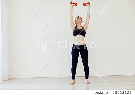 Female athlete engaged in fitness with dumbbells sport 58652122