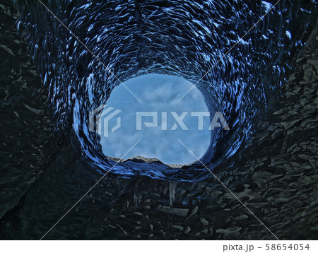 A large opening in a blue glacier cave 58654054