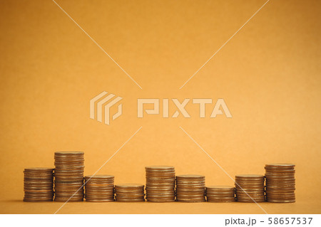 Columns of coins, piles of coins on brown 58657537
