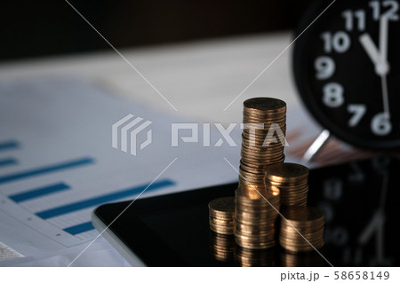 Step of coins stacks and alarm clock with tablet Step of coins stacks and alarm clock with tablet 58658149