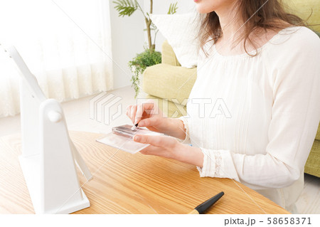 自宅で化粧をする若い女性 58658371