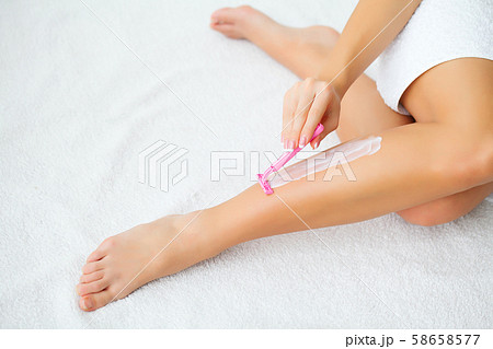 Young woman removing hair on legs with razor. Body care and shaving every day. Smooth skin. Young woman removing hair on legs with razor. Body care and shaving every day. Smooth skin. 58658577