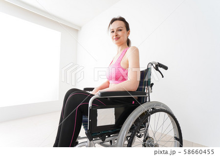 スポーツウェアを着て車椅子に乗る外国人の女性 58660455