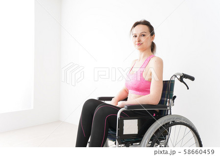 スポーツウェアを着て車椅子に乗る外国人の女性 58660459