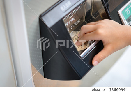 Japan, Tokyo - August 30 2019: Hand of a child take the Gondola sky shuttle ticket from the ticket machine to ride to the amusement park. Japanese, urban lifestyle, Automatic, Payment, Purchasing. 58660944
