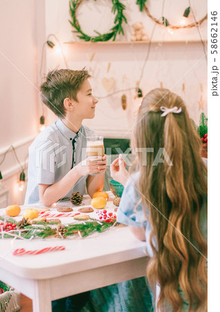 Cute little sister with long hair and an older brother drink cocoa in anticipation of Christmas. Christmas mood 58662146