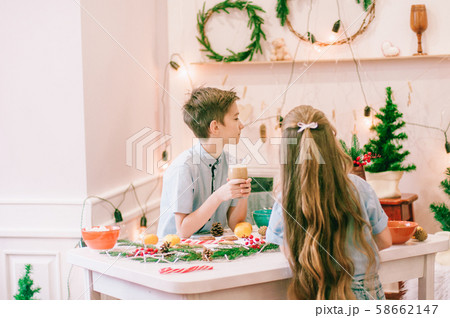 Cute little sister with long hair and an older brother drink cocoa in anticipation of Christmas. Christmas mood 58662147