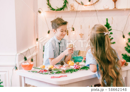 Cute little sister with long hair and an older brother drink cocoa in anticipation of Christmas. Christmas mood 58662148