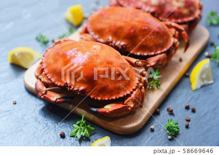 Cooked crabs on wooden board with lemon on plate 58669646