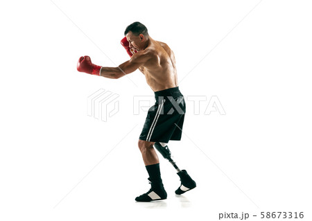 Full length portrait of muscular sportsman with prosthetic leg, copy space. Male boxer in red gloves Full length portrait of muscular sportsman with prosthetic leg, copy space. Male boxer in red gloves 58673316