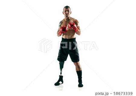 Full length portrait of muscular sportsman with prosthetic leg, copy space. Male boxer in red gloves Full length portrait of muscular sportsman with prosthetic leg, copy space. Male boxer in red gloves 58673339