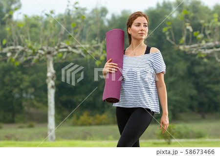 Young beautiful woman doing yoga exercise in green park. Healthy lifestyle and fitness concept. Young beautiful woman doing yoga exercise in green park. Healthy lifestyle and fitness concept. 58673466