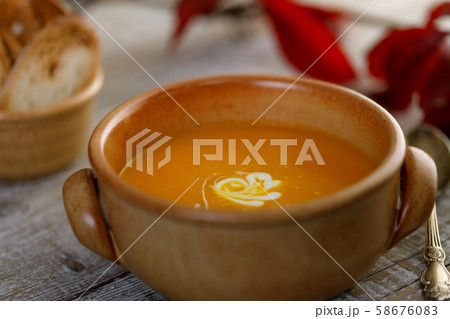 Pumpkin cream soup in a ceramic dish 58676083