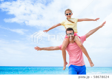 Little girl and happy dad having fun during beach vacation Little girl and happy dad having fun during beach vacation 58678024