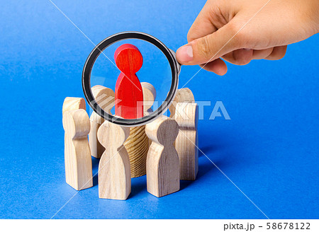 A magnifying glass looks at a red figure of the leader in the center of the circle of people. Creating a business team and its management. Cooperation and collaboration. Fundraising A magnifying glass looks at a red figure of the leader in the center of the circle of people. Creating a business team and its management. Cooperation and collaboration. Fundraising 58678122