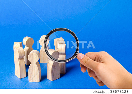 A magnifying glass looks at a people figurines stand in a circle. discussion, cooperation. Meeting at work, negotiating a plan of action. teamwork. Employees briefing. Organization of work processes A magnifying glass looks at a people figurines stand in a circle. discussion, cooperation. Meeting at work, negotiating a plan of action. teamwork. Employees briefing. Organization of work processes 58678123