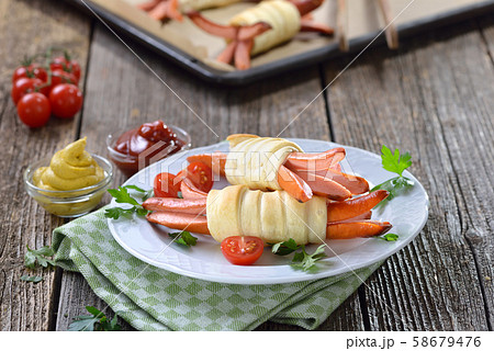 Baked Vienna sausages wrapped with puff pastry fresh from the oven,often served as a children’s meal 58679476
