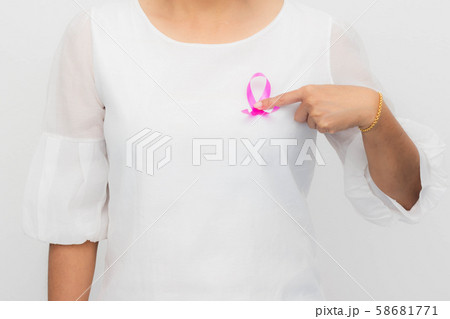 Pink ribbon on woman chest to support breast cancer cause. Healthcare, medicine and breast cancer awareness concept. Pink ribbon on woman chest to support breast cancer cause. Healthcare, medicine and breast cancer awareness concept. 58681771