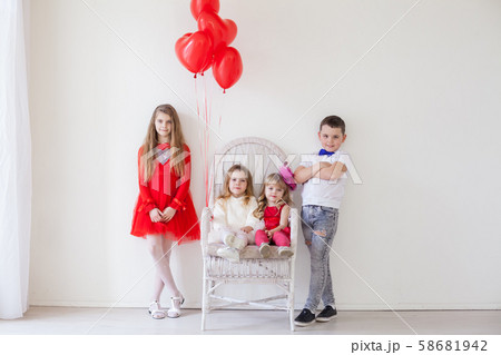 three girls and a boy in a white room with red holiday balloons 58681942