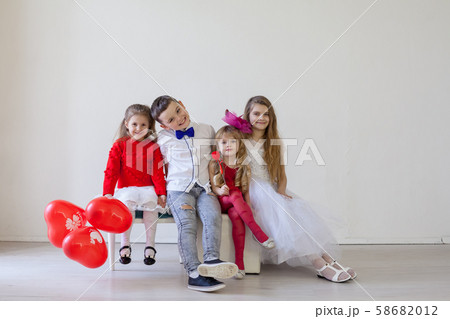 three girls and a boy in a white room with red balloons three girls and a boy in a white room with red balloons 58682012