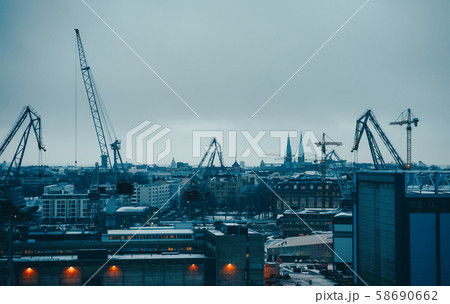Image of river, floating cranes, buildings on river bank. 58690662