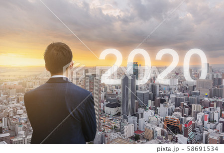 Businessman looking at city sunrise with 2020 new year in the city Businessman looking at city sunrise with 2020 new year in the city 58691534