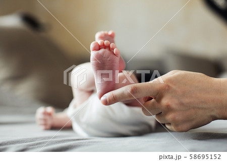 Mother holding newborn baby feet in hands Mother holding newborn baby feet in hands 58695152