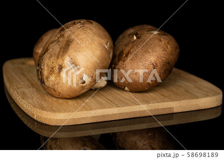 Fresh brown mushroom isolated on black glass Fresh brown mushroom isolated on black glass 58698189