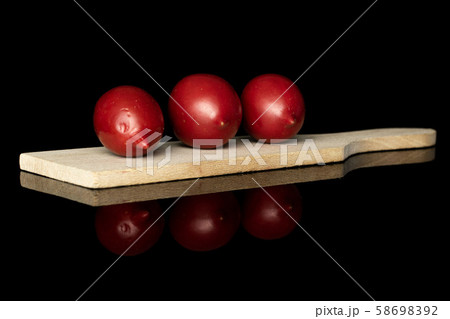 Fresh tomato de barao isolated on black glass Fresh tomato de barao isolated on black glass 58698392