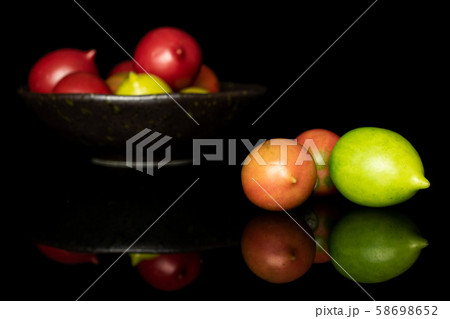 Fresh tomato de barao isolated on black glass Fresh tomato de barao isolated on black glass 58698652